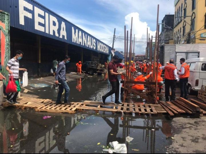 Com ruas alagadas, cerca de 150 feirantes da Manaus Moderna vão trabalhar em balsa